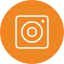 An orange circular icon with a white outline of a camera resembling the Instagram logo, featuring a square shape with a central circle and a small dot in the upper right corner.