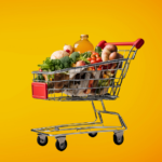 A shopping cart filled with groceries, including vegetables, bread, eggs, and a bottle, against a bright orange background.