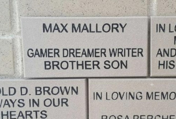 A memorial brick reads: "Max Mallory. Gamer Dreamer Writer Brother Son" in bold black letters on a light-colored background, set in a wall with other engraved bricks.