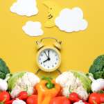 A yellow alarm clock sits among fresh vegetables like bell peppers, cauliflower, broccoli, and tomatoes, with paper clouds and a crescent moon on a yellow background above.