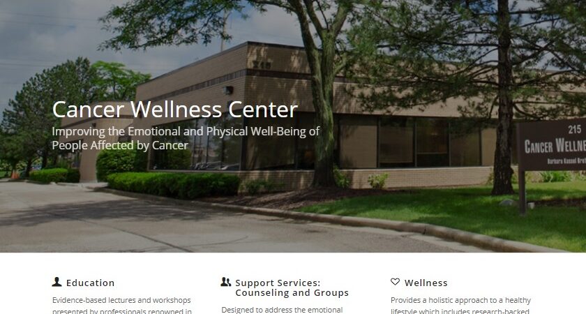 Screenshot of the Cancer Wellness Center website homepage, featuring navigation menus, a green donate button, a chat option, and information about education, support services, and wellness for people affected by cancer.