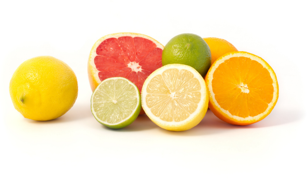 A group of citrus fruits including a lemon, lime, orange, and grapefruit, some whole and some cut in half, arranged on a white background.